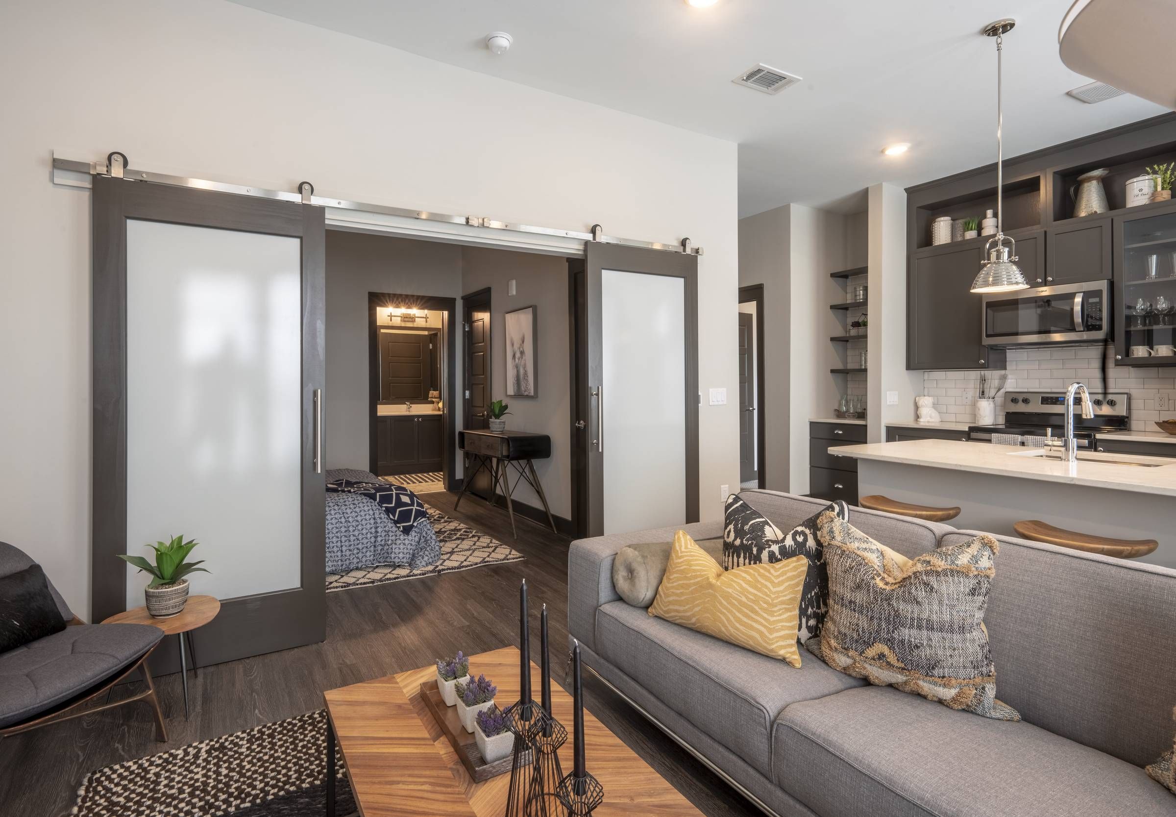 Residences at Capitol View luxury apartment interior with grey couch and wooden coffee table