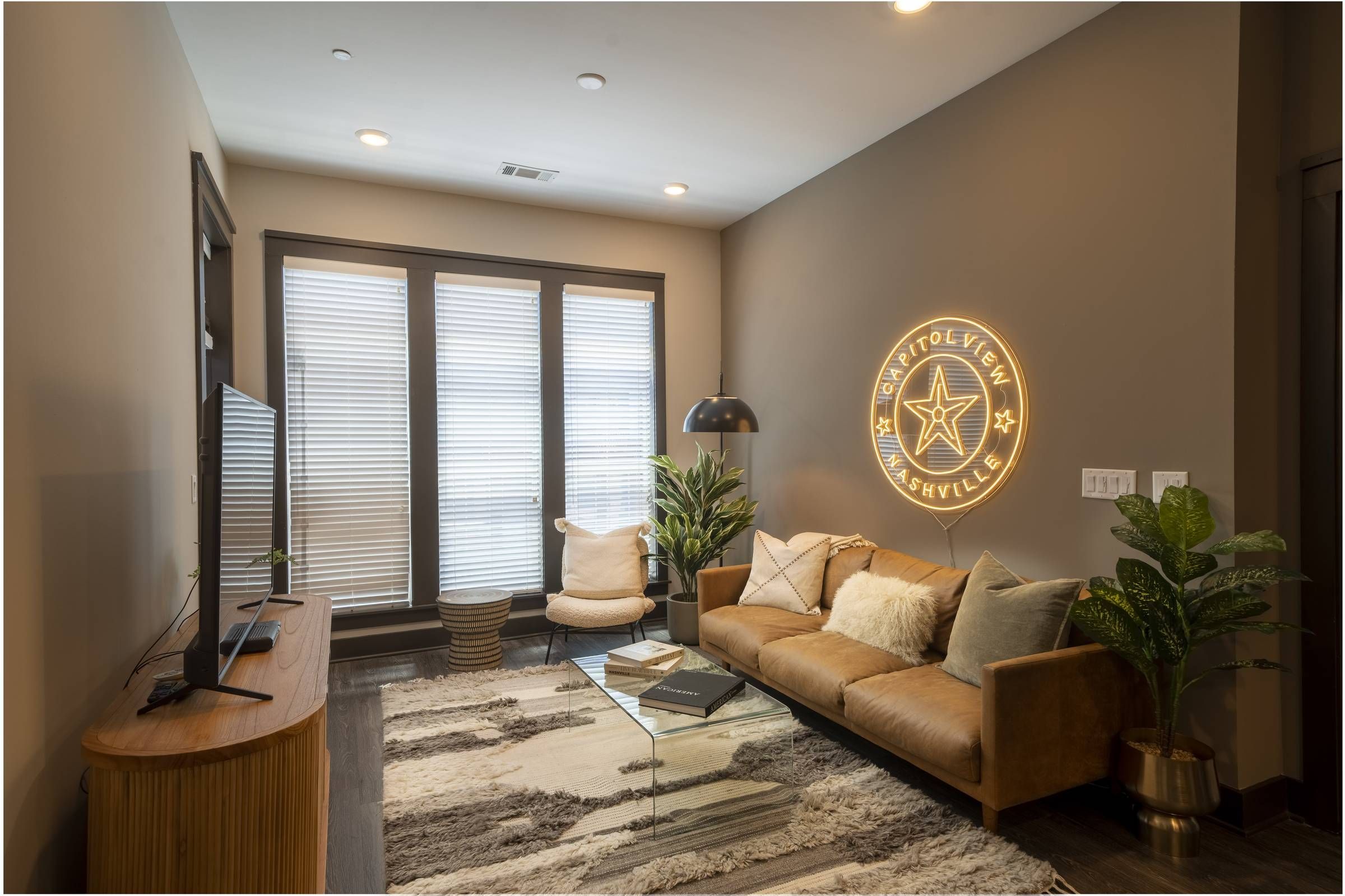 Residences at Capitol View luxury apartment interior with leather couch and floor to ceiling windows