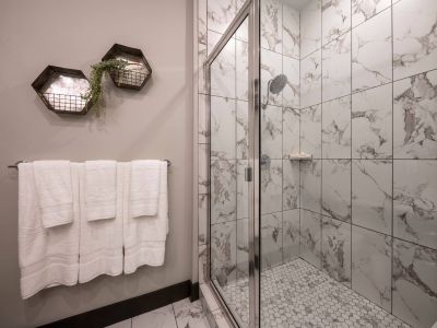 Residences at capitol view luxury bathroom with modern white tile and rainfall showerhead