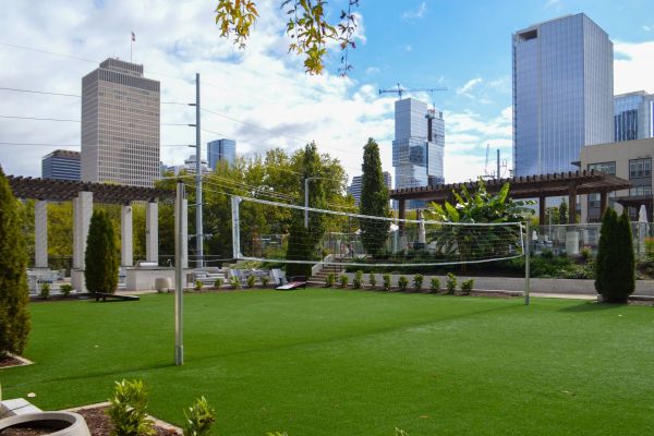 Residences at capitol view luxury apartment rooftop volleyball amenity with green turf and seating surrounding the court