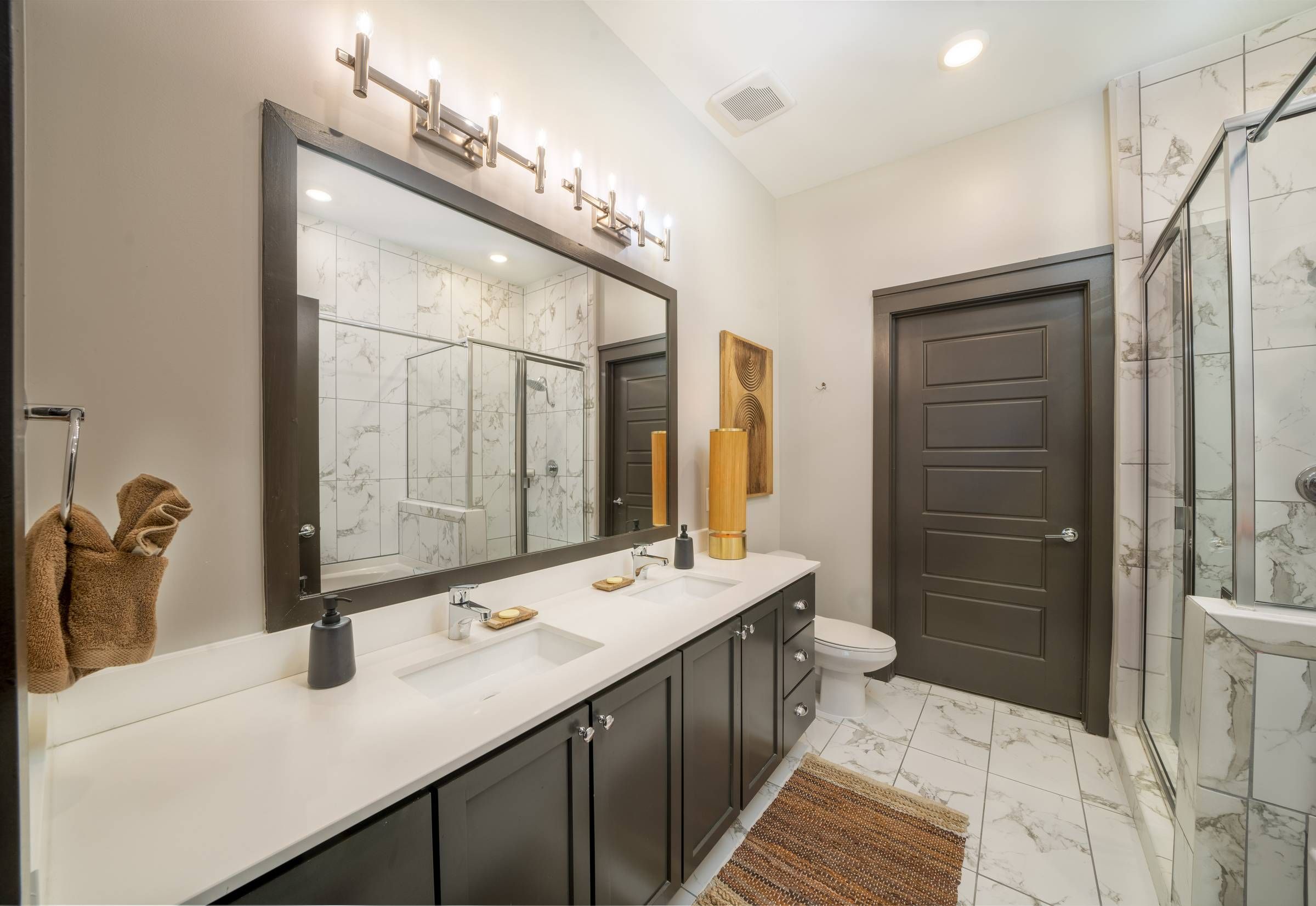 Residences at capitol view luxury guest suite bathroom with white countertops and marble tile