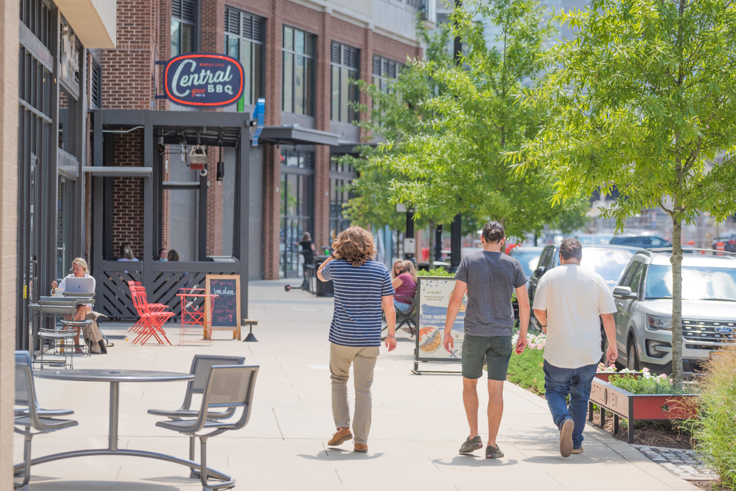 Residences at capitol view gulch neighborhood people walking down the street next to shops