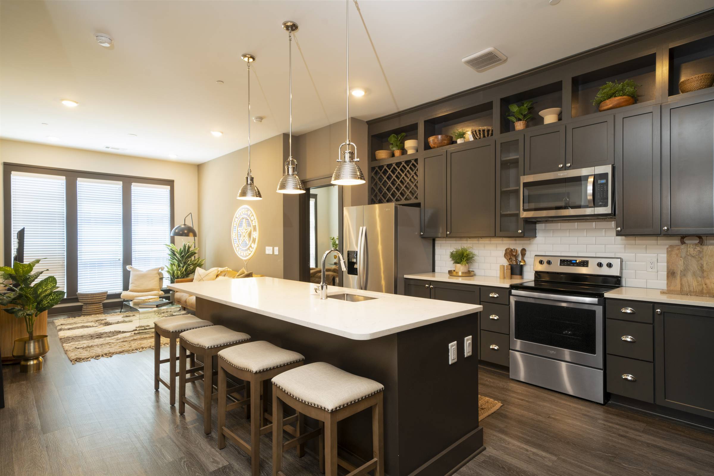 Residences at Capitol View luxury apartment interior with kitchen island and stainless steel appliances