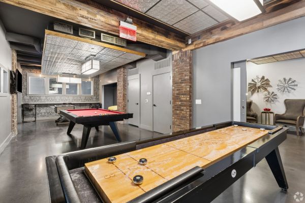 Residences at Capitol View Resident game room with pool table, foosball, and pinball machines